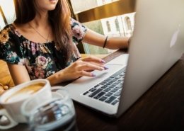 Woman working at a computer with coffee