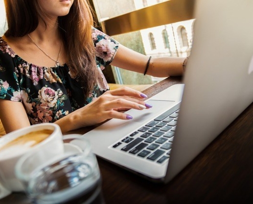 Woman working at a computer with coffee