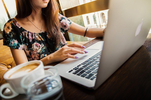 Woman working at a computer with coffee