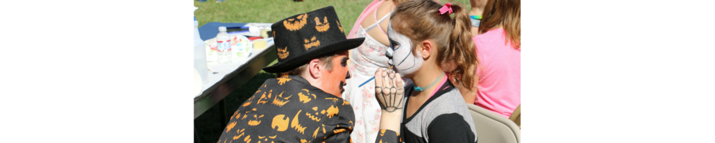 Student enjoying face-painting at a Harvest Festival