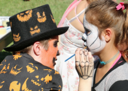 Student enjoying face-painting at a Harvest Festival