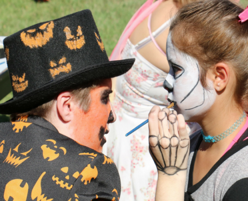 Student enjoying face-painting at a Harvest Festival