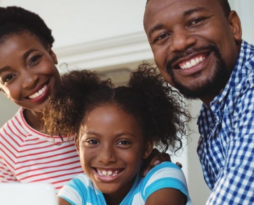 Portrait of happy parents and daughter using digital tablet in kitchen at home