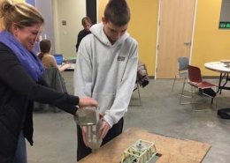 Image of student and teacher testing toothpick bridge with weight