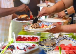 Guests filling plates at a summer cookout