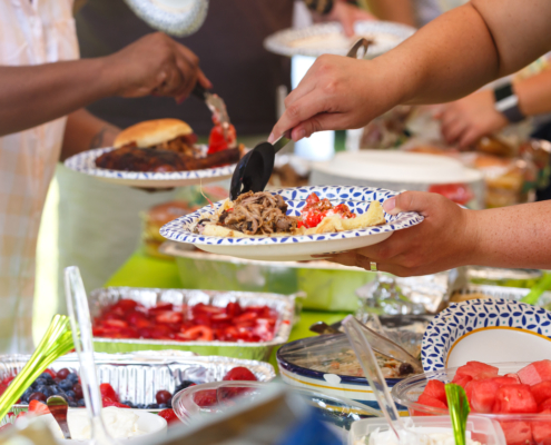 Guests filling plates at a summer cookout