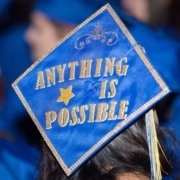 Blue Graduation Cap with Anything is possible spelled out in gold glitter letters