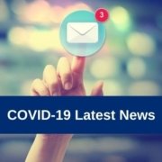 Hand pressing an email icon on blurred cityscape background with COVID-19 Latest News text overlay