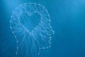Learning to love concept. Network of pins and threads in the shape of a cut out heart inside a human head symbolising that love is the core of our being and has its own logic. (Learning to love concept. Network of pins and threads)
