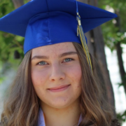 Marina smiles at the camera in blue graduation cap and gown; graduating from online high school