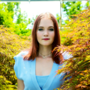 Female young adult smiles at camera in senior photo; graduating from online high school