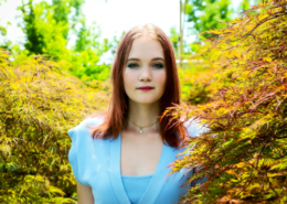 Female young adult smiles at camera in senior photo; graduating from online high school