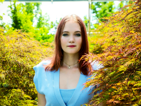 Female young adult smiles at camera in senior photo; graduating from online high school