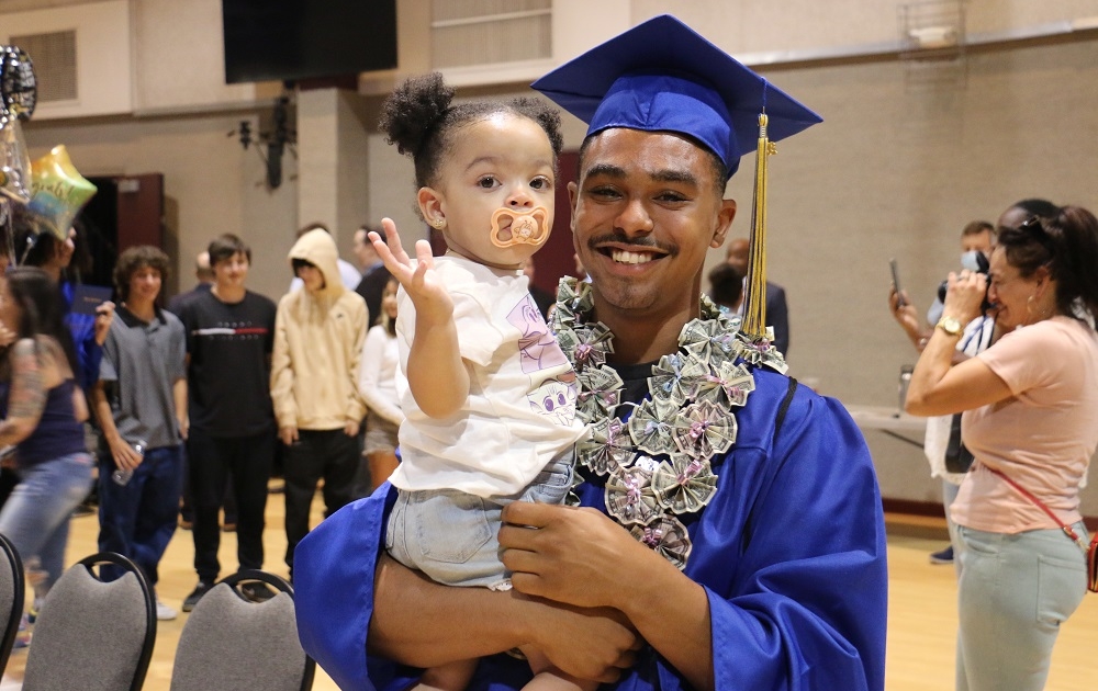 High school graduate celebrates at summer graduation after catching up on credits