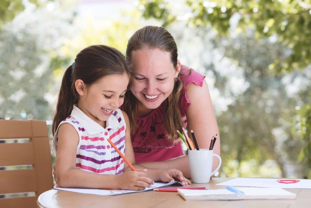 Homeschooling mom working with daughter on schoolwork at home