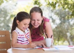Homeschooling mom working with daughter on schoolwork at home