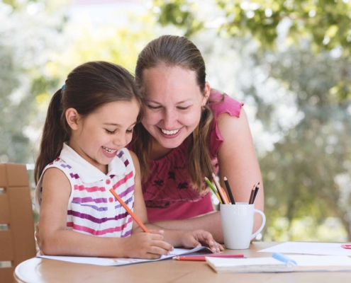 Homeschooling mom working with daughter on schoolwork at home