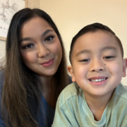 Smiling parent educator and her home school student read a book