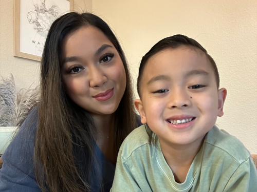 Smiling parent educator and her home school student read a book