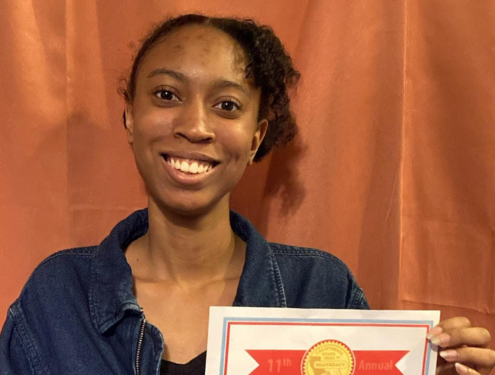 Smiling home school student holds up her State Seal of Biliteracy certificate