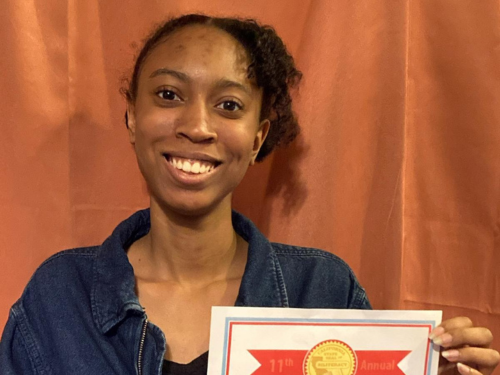 Smiling home school student holds up her State Seal of Biliteracy certificate