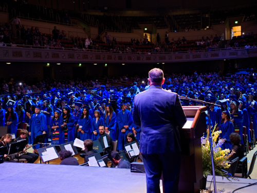 Superintendent looks out into the crowd of graduates from the podium at graduation