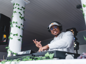 Raeshon M. Office Staff Spotlight web Male dj smiles at the camera on stage at event