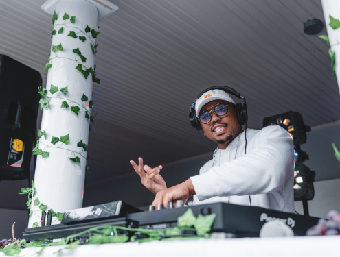 Male dj smiles at the camera on stage at event