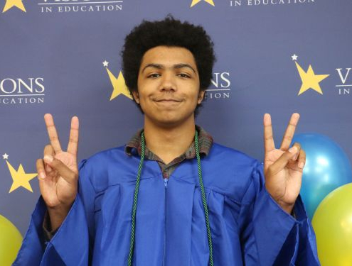 Lenny, eSports champ, Visions graduate and STS staff member gives the peace sign at high school graduation