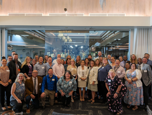 Large group of Visions leaders, administrators and managers gather and smile for a group photo