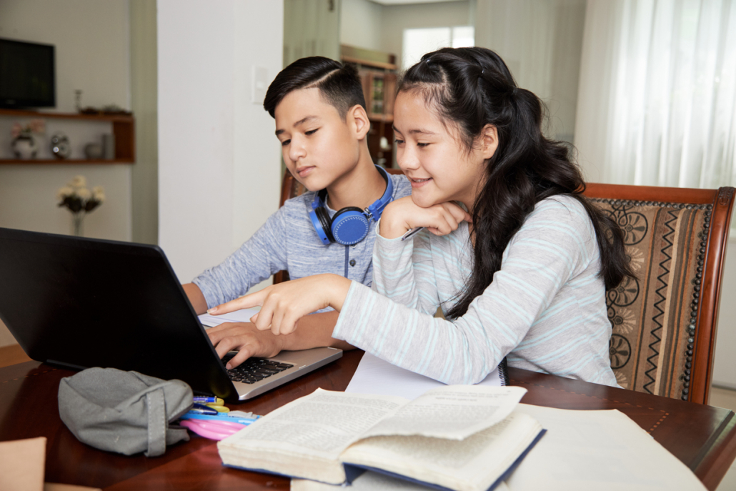 Teenage siblings studying at home due, they are watching online lecture together