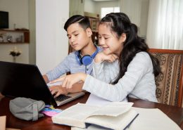 Teenage siblings studying at home due, they are watching online lecture together