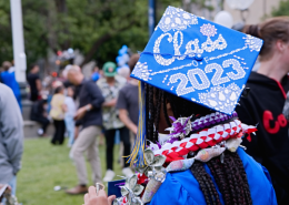 Photo taken from the back of a girl wearing a blue Visions graduation cap with "Class of 2023" written in rhinestones on the top.