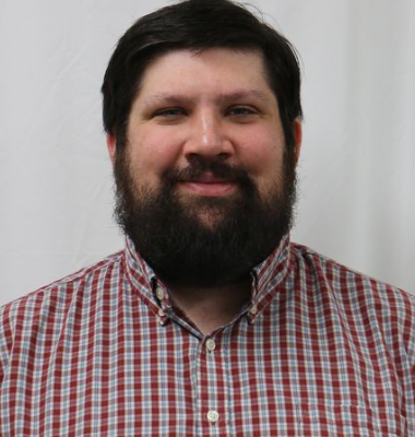 Michael Miller (staff member) in a red plaid shirt smiles for a staff photo.