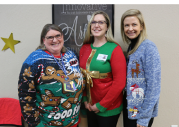 Loretta, Jessica and Kim stand together and pose for a photo wearing Christmas sweaters.