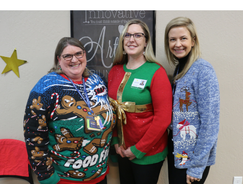 Loretta, Jessica and Kim stand together and pose for a photo wearing Christmas sweaters.