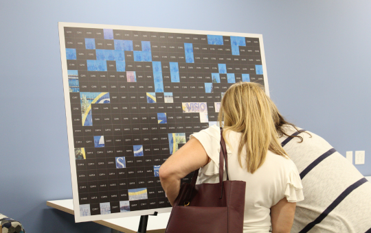 Photo of Visions staff adding to a photo mural.