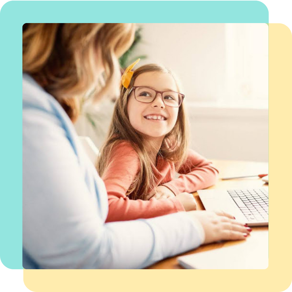 Girl with glasses smiling up at a teacher out of frame