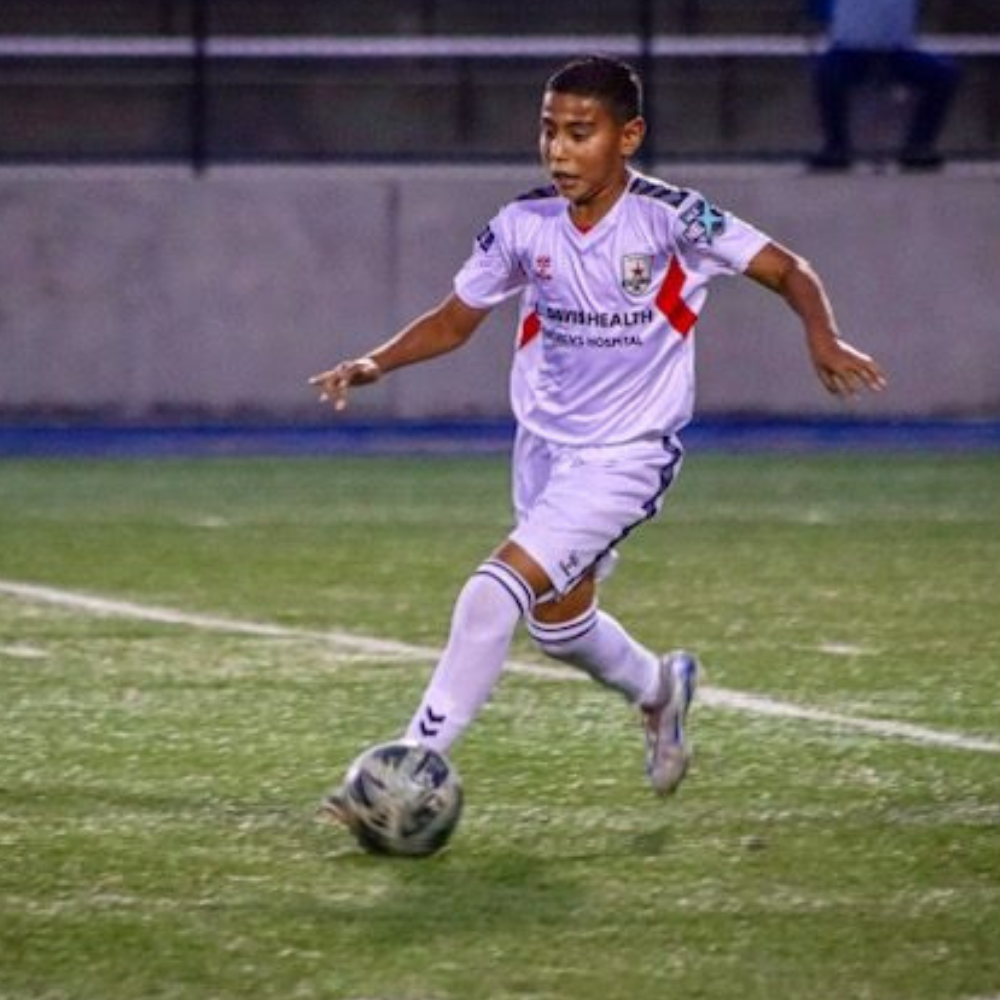 Young man kicking soccer ball