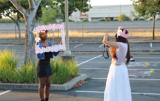 A Visions students takes a photo of another student using their photo frame
