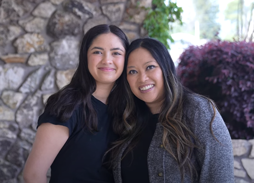 Mother and daughter smile together.
