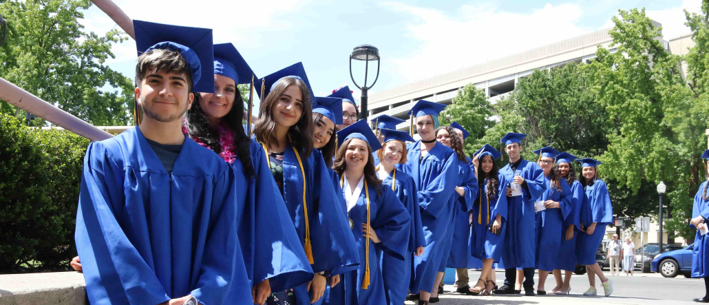 Group photo of Visions graduates smiling in blue caps and gowns