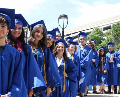 Group photo of Visions graduates smiling in blue caps and gowns