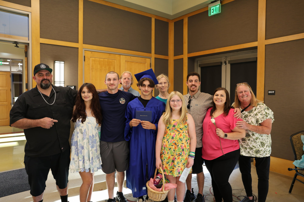 A summer graduate and his family gather together for a group photo.