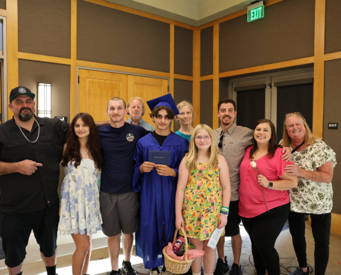A summer graduate and his family gather together for a group photo.