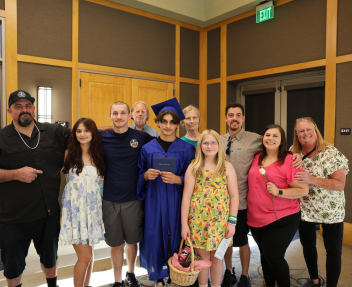 A summer graduate and his family gather together for a group photo.