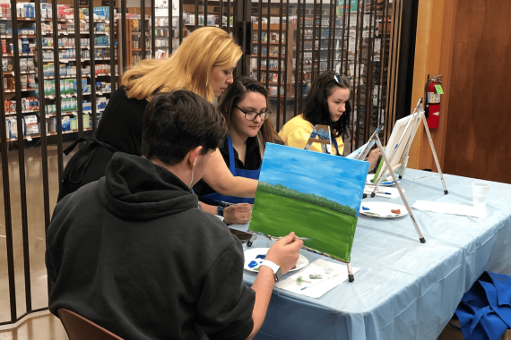 Teacher and students painting in a class