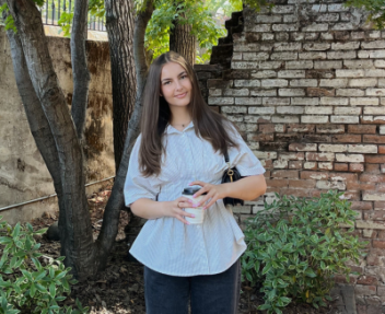 Visions student holding a cup of coffee