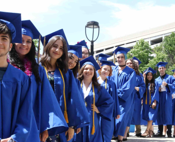 Group photo of Visions graduates smiling in blue caps and gowns