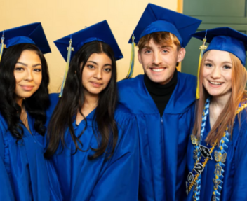 Visions graduates smiling in blue caps and gowns